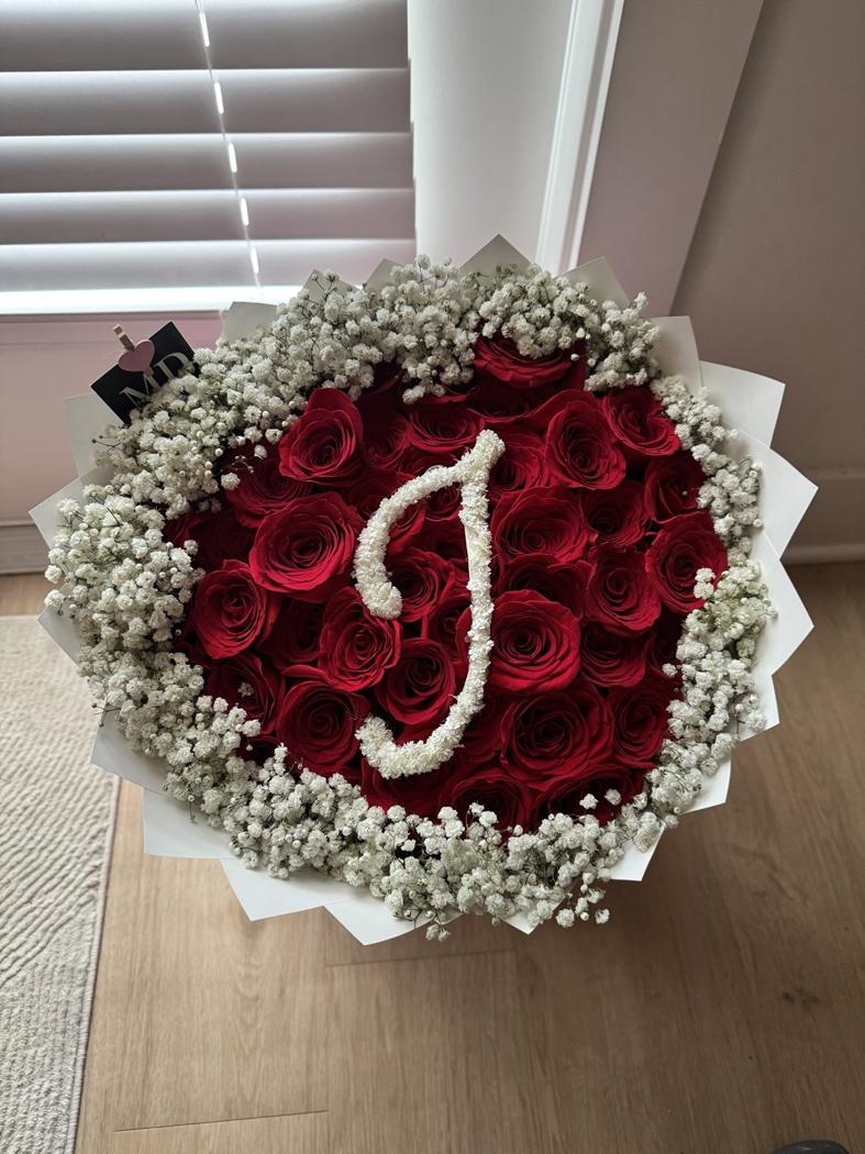 Red rose bouquet with white baby’s breath border and personalized initial