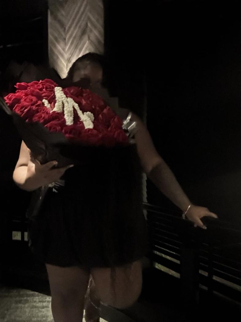 Mia holding a red rose bouquet